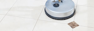 Tile floor mid-clean, showing restored grout lines against the untreated section